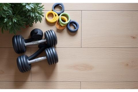 Adjustable dumbbells and a resistance band set, arranged neatly in a home gym setting.