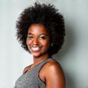 Professional headshot of Coach Alex Lee, a fit Black woman in her late 30s, smiling confidently