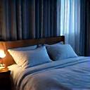 A cozy, dimly lit bedroom with crisp white linens and soft lighting, suggesting optimal sleep environment and rest